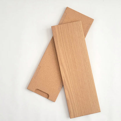 TALAYA Solid Ground tiles in Honey Oak finish on white background, both angled, one tile face-up and one cork-side up showing built-in attachment points and handle