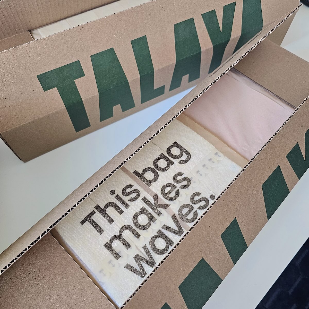 Two open TALAYA Solid Ground packaging boxes with wrapped tiles on white background